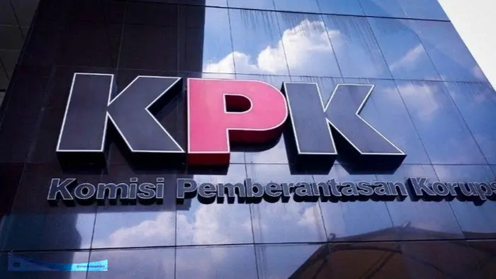 Tampak Gedung Komisi Pemberantasan Korupsi (KPK) di Jakarta dengan logo KPK pada fasad bangunan, berlatar langit siang hari dan area depan gedung.