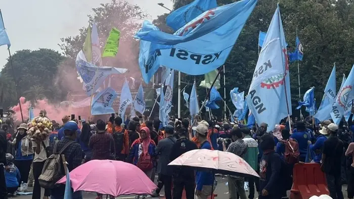 Kerumunan buruh berkumpul di kawasan Monas dengan membawa atribut serikat pekerja saat perayaan May Day.