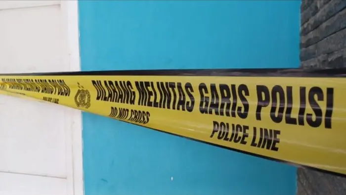 Pita kuning bertuliskan "Dilarang Melintas Garis Polisi" terpasang di sebuah bangunan sebagai tanda pengamanan area TKP oleh pihak kepolisian.