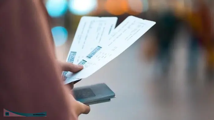 Seseorang memegang tiket pesawat dan paspor di area bandara sebagai simbol keberangkatan ke luar negeri