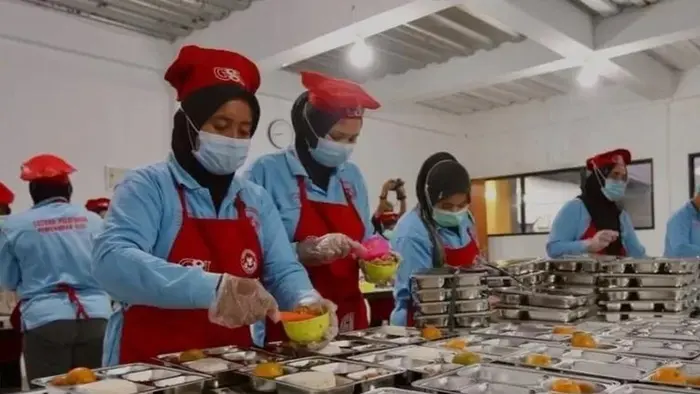 Suasana aktivitas pekerja dalam proses penyiapan dan distribusi makanan bergizi di dapur umum program MBG