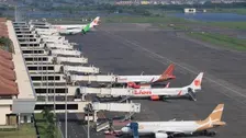 Foto memperlihatkan pemandangan udara barisan pesawat dari berbagai maskapai yang terparkir berjajar di garbarata terminal bandara, di antaranya tampak livery Citilink, Batik Air, Lion Air, serta maskapai lain berwarna oranye. Bangunan