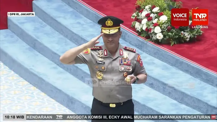 Komjen Pol. Suyudi Ario Seto tampak mengenakan seragam kepolisian lengkap dengan berbagai tanda jasa dan lencana kehormatan, berdiri di hadapan tangga berlatar merah sambil memberi hormat.
