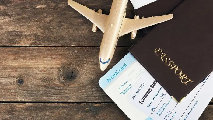 Paspor dan dokumen visa diletakkan di atas permukaan sebagai simbol perjalanan internasional.