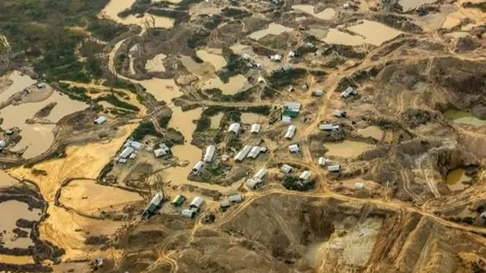 Tampak area tambang dengan banyak lubang galian dan genangan air serta permukiman di sekitarnya yang menunjukkan aktivitas penambangan tanpa izin.