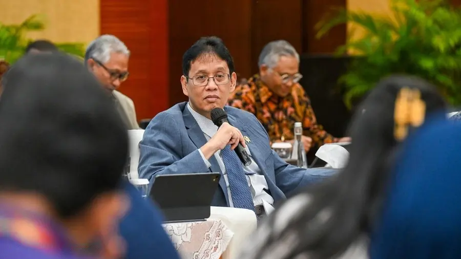 Menteri Keuangan Purbaya Yudhi Sadewa tampak berbicara menggunakan mikrofon dalam sebuah pertemuan resmi. Mengenakan jas biru dengan dasi bermotif, ia duduk di antara sejumlah peserta rapat sambil mem Menteri Keuangan Purbaya Yudhi Sadewa tampak berbicara menggunakan mikrofon dalam sebuah pertemuan resmi. Mengenakan jas biru dengan dasi bermotif, ia duduk di antara sejumlah peserta rapat sambil mem