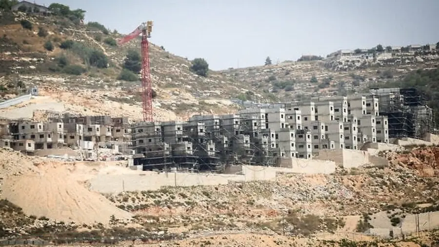 Foto menunjukkan konstruksi bangunan bertingkat di kawasan perbukitan Tepi Barat dengan crane merah berdiri di tengah proyek pembangunan permukiman Israel. Foto menunjukkan konstruksi bangunan bertingkat di kawasan perbukitan Tepi Barat dengan crane merah berdiri di tengah proyek pembangunan permukiman Israel.
