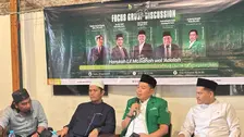 H. Dendy Zuhairil Finsa SH MH selaku Ketua LBH PP GP Ansor tampak berbicara sambil memegang mikrofon mengenakan jaket hijau berlogo GP Ansor, didampingi para narasumber lain yang duduk berjajar di hadapan spanduk FGD berlatar hijau gelap bertuliskan tema acara dan foto para pembicara.