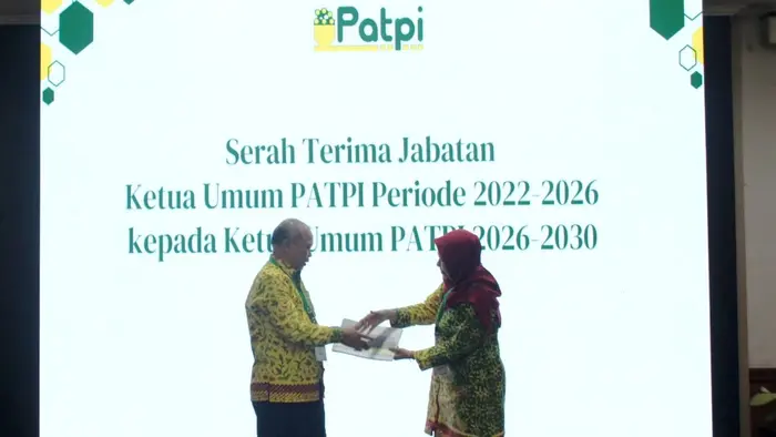 Foto memperlihatkan momen serah terima jabatan Ketua Umum Perhimpunan Ahli Teknologi Pangan Indonesia (PATPI) di atas panggung, dengan layar besar di latar belakang bertuliskan "Serah Terima Jabatan Ketua Umum PATPI Periode 2022-2026 kepada Ketua Umum PATPI 2026-2030" beserta logo PATPI. Kedua tokoh tampak mengenakan batik bernuansa hijau kuning saat saling menyerahkan berkas jabatan, disaksikan oleh peserta kongres. Di sisi kiri panggung terlihat bendera PATPI, sementara bagian depan panggung dihiasi rangkaian bunga.