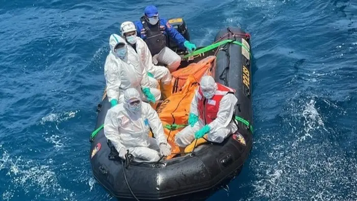 Sejumlah personel tim SAR mengenakan pakaian pelindung berada di atas perahu karet saat membawa kantong evakuasi berwarna oranye di tengah perairan Laut Jawa