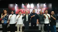 Delapan orang berdiri berjajar di atas panggung dengan pose mengepalkan tangan, berlatar backdrop bertuliskan "DISKUSI PUBLIK JILID III" dengan tema "Sinergi Antar-Lembaga dalam Membongkar Jaringan TPPO dan Menjamin Hak Pekerja Migran".