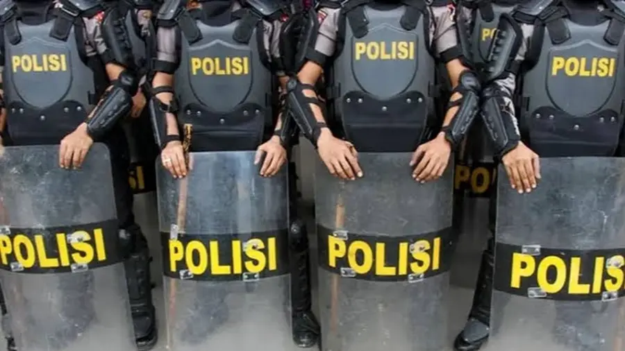 Polisi Siapkan Skenario Rekayasa Lalu Lintas Selama Demo Mahasiswa di DPR Barisan personel polisi berompi antipeluru bertuliskan "POLISI" berdiri berdampingan sambil memegang perisai transparan. Tampak pelindung lengan di tangan mereka. Wajah personel tidak terlihat karena foto diambil dari bagian dada ke bawah.