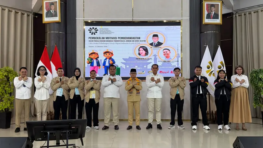 Menteri Mukhtarudin Lepas 357 PMI ke Korsel dan Jerman Lewat Program G to G Sebelas orang berdiri berjajar di panggung dengan kedua tangan disilangkan di dada. Sebagian mengenakan kemeja putih, sebagian jaket krem atau hitam, dan seorang di tengah berpeci hitam memakai selendang kuning. Di belakang mereka terdapat layar bertulisan "Pembekalan Motivasi Pemberangkatan Calon Pekerja Migran Indonesia Penempatan ke Jerman dan Korea Selatan", dengan bendera Merah Putih dan foto presiden serta wakil presiden di sisi kiri dan kanan.